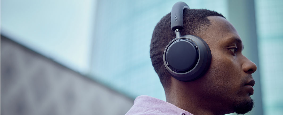 Un hombre escuchando música con unos auriculares Philips X3.