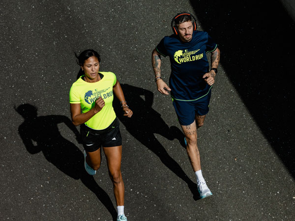 Dos participantes corren para mantenerse por delante del coche de control.