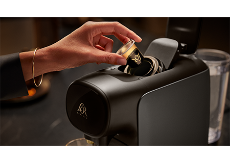 Alguien poniendo una taza de caf&eacute; L&rsquo;OR en la cafetera de c&aacute;psulas L&rsquo;OR Sublime